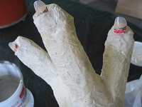 detail of plastic fingernails added to latex-covered gloves